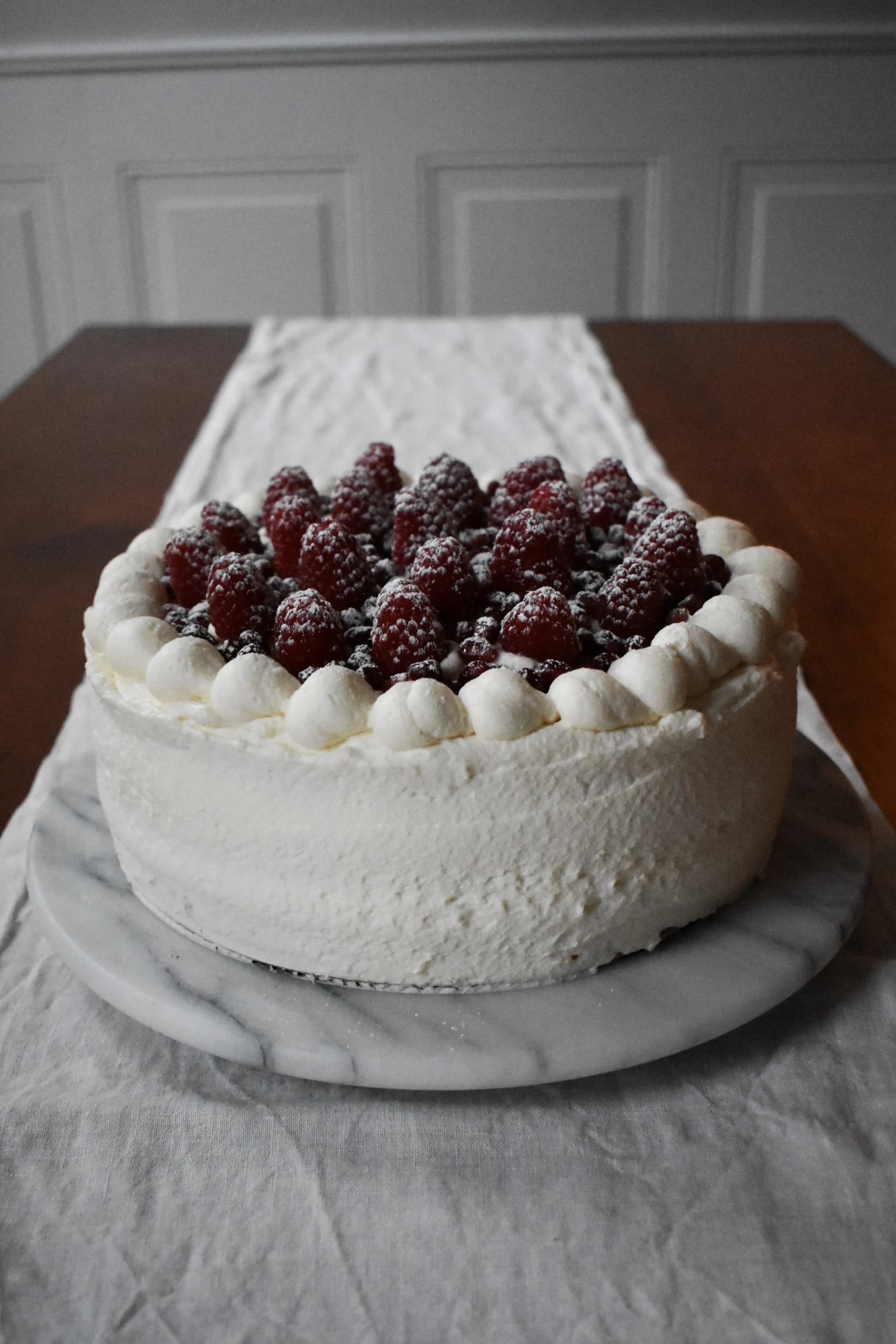 vanilla cake topped with blackberries and powdered sugar